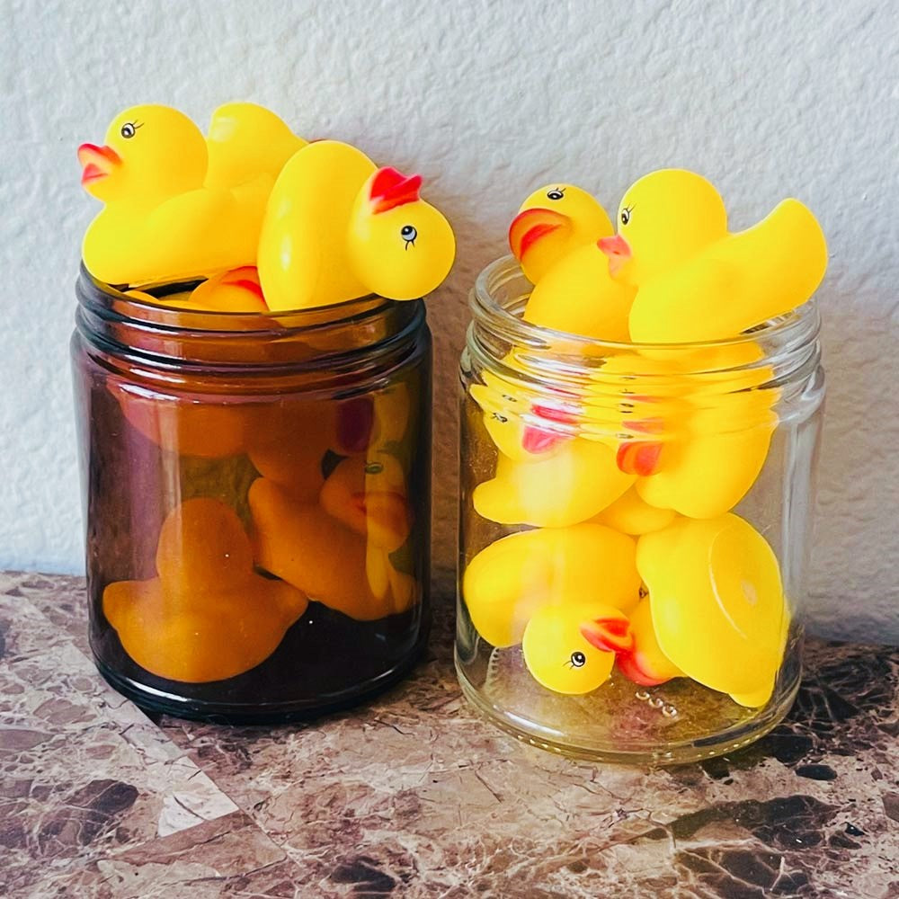 shows our 9oz candle jars being reused for other purposes. In this photo, it shows a number of small toy rubber duckies in the jars for storage.