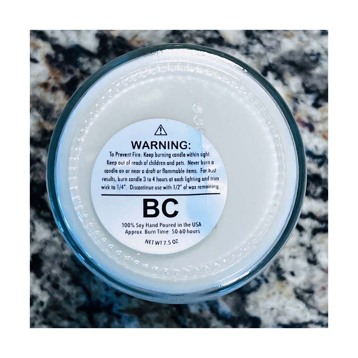 Shows the safetly labels on the bottom of our 9oz candles. The Safetly label meets the National Candle Associations safety standards for fire safety.