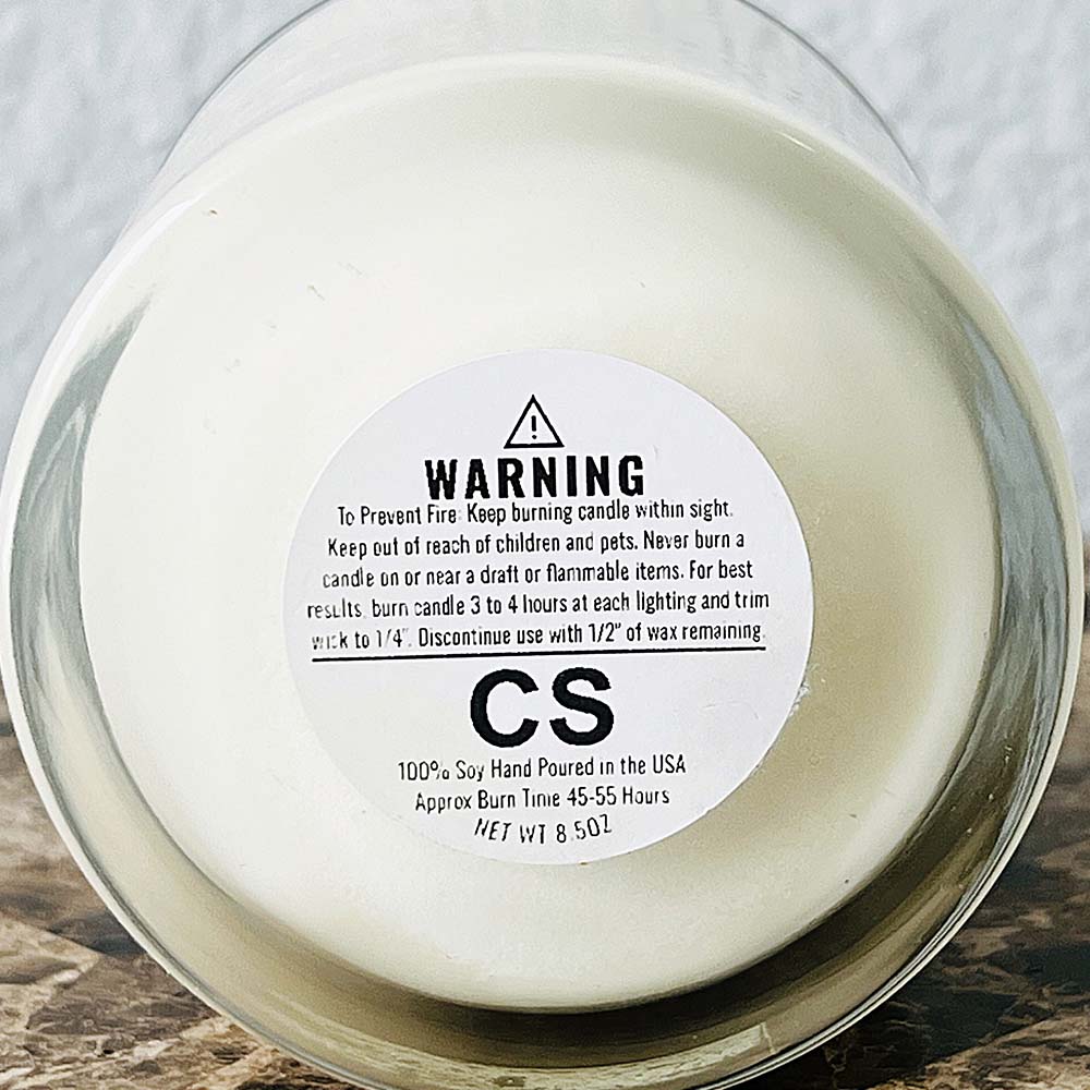 Bottom of an 11oz candle showing the safety label with the burn instructions. 