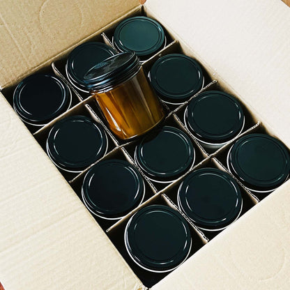 Box of 12 9oz amber jar candles with lids. Shows what you will order from Candle Builders with a wholesale candle order. 