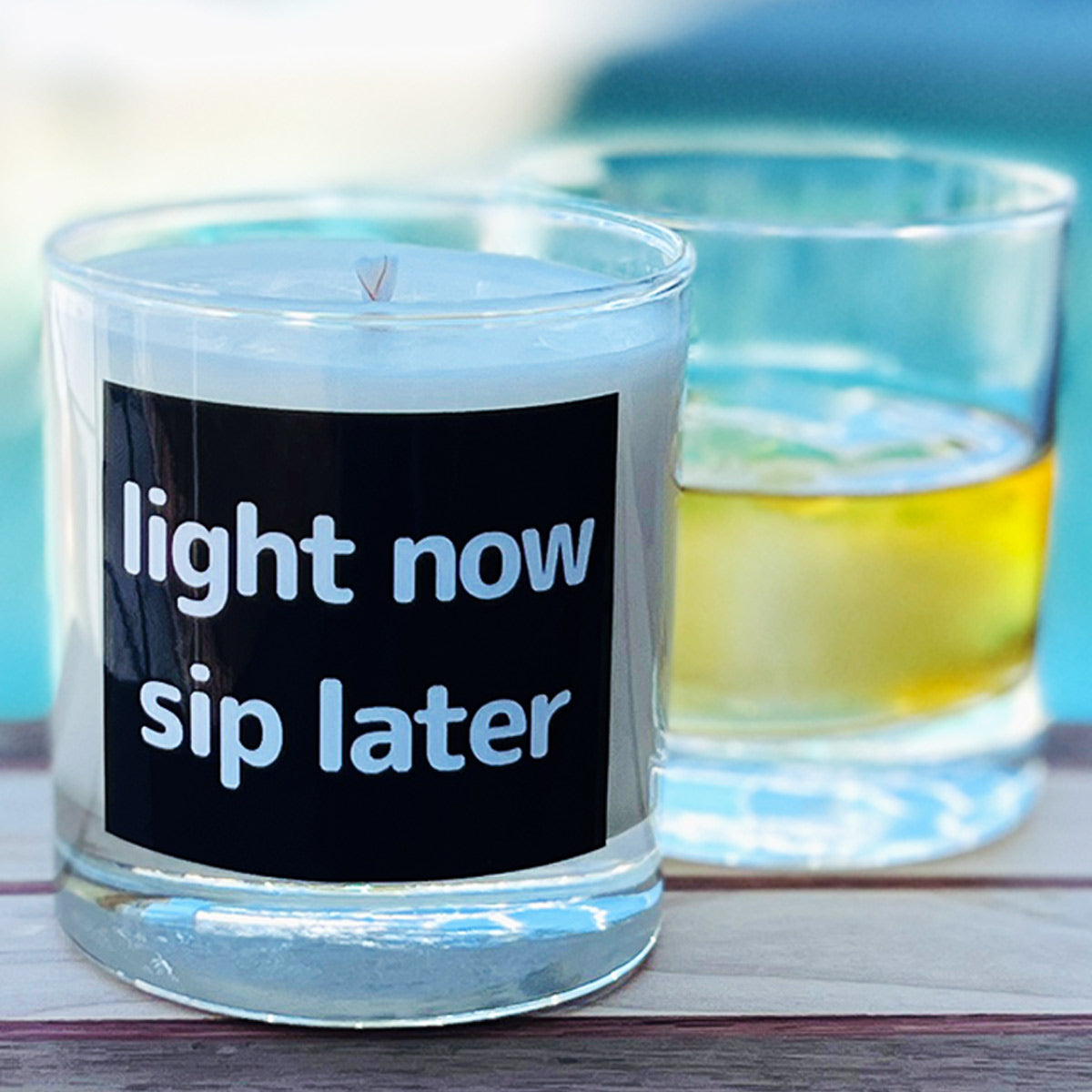 11oz tumbler candle showing an example candle. behind it is the same tumbler being used as a rocks glass. THis image shows the dual purpose of the glass. 