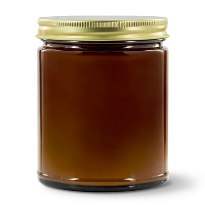Jar of brown jelly with a gold lid on a white background