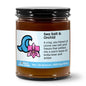 Jar of candle labeled 'Sea Salt & Orchid' with a wave and flower design on a white background
