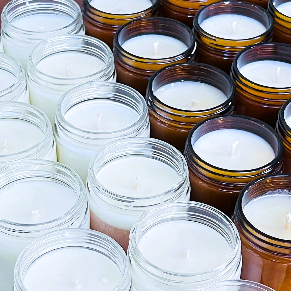 Bulk Wholesale 9oz Jar 100% Soy Hand Poured Candles - Image showing a bunch of amber and clear jar candles.  The wax in the candles are also white for any scent. 
